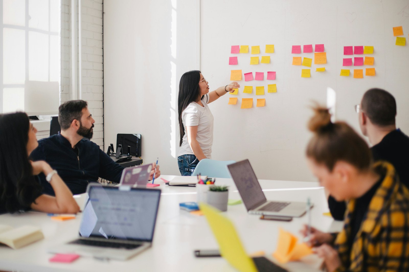 A product team gathered around a wall of sticky notes
